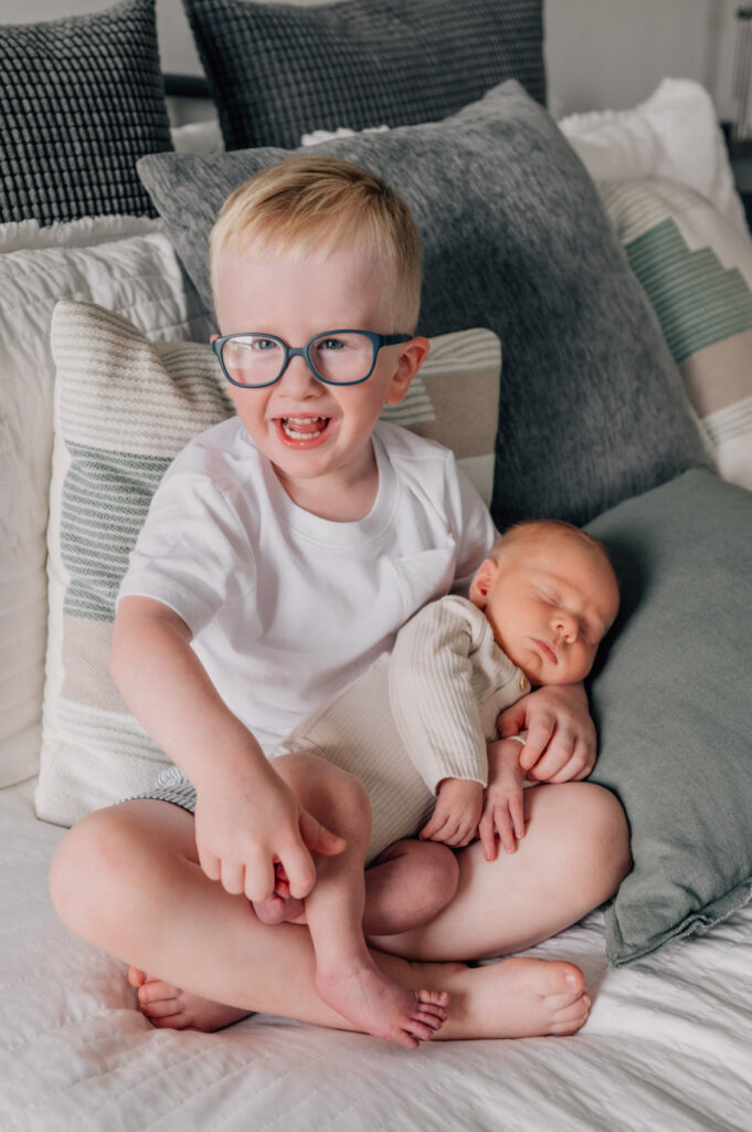 3yo boy holding his newborn baby brother during in-home newborn session in Columbia SC