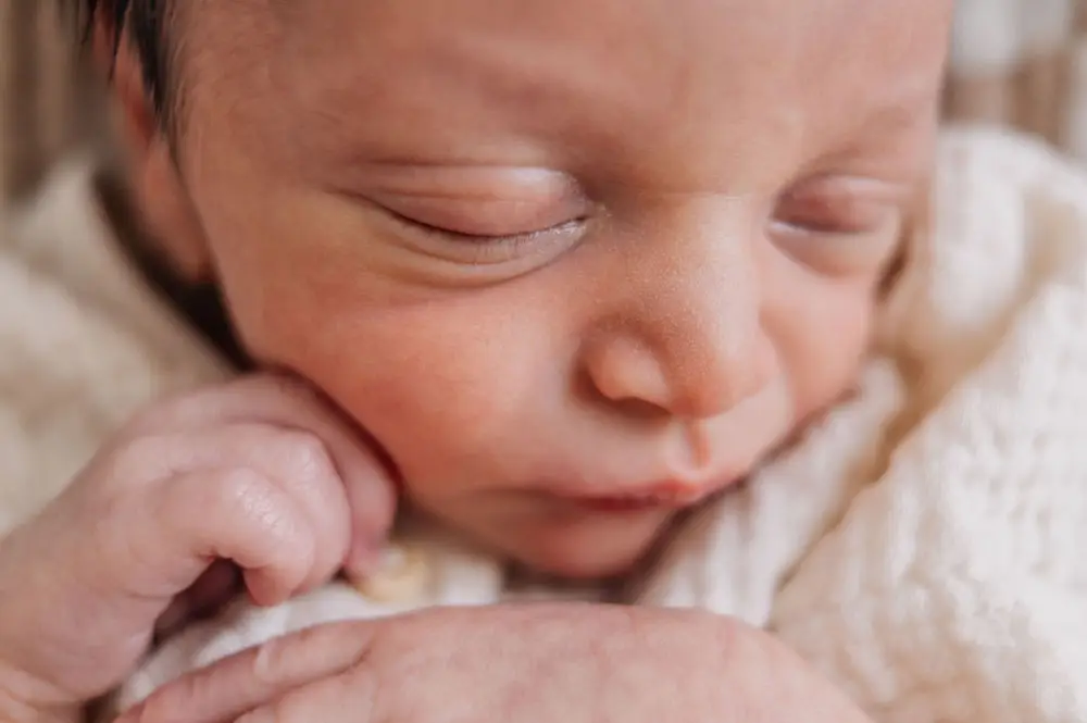 Sweet little baby boy during newborn photo session at home.