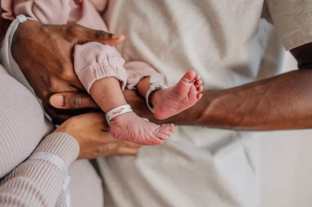 Details of newborn baby feet while laying in mom and dad's arms thanks to childbirth classes in Columbia, SC